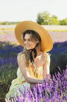 Beautiful young woman in a field full of lavender flowers photo