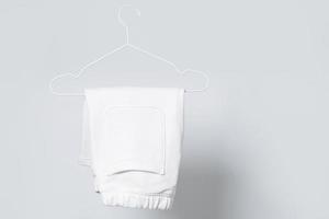 Blank white shorts hanging on a hanger against gray background photo