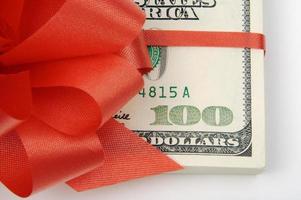 One Hundred Dollar Bills Wrapped in Red Ribbon. photo