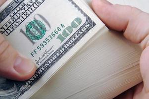 Man Fanning Large Stack of One Hundred Dollar Dollar Bills photo