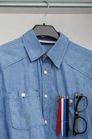 Shirt with colorful pens and eyeglasses in pocket photo