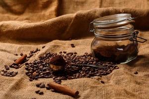 Roasted coffee beans and scoop with milled coffee photo