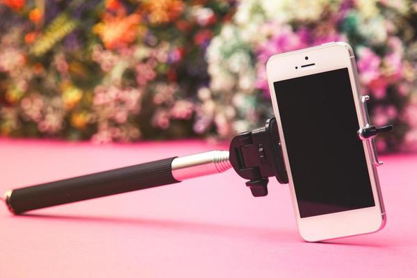 Selfie stick on background with flowers