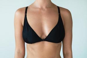 Woman with natural breast wearing black swimwear top photo