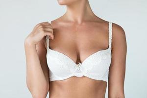 Woman with natural breast wearing white bra photo