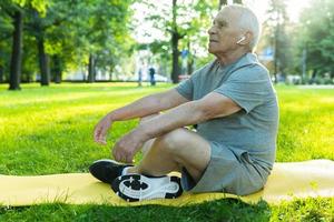 anciano relajándose en el parque de la ciudad verde después de su entrenamiento foto