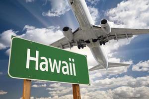 señal de carretera verde de hawaii y avión arriba foto