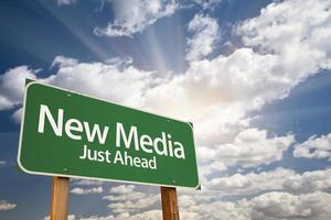 New Media Green Road Sign Against Clouds photo