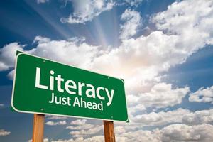 Literacy Green Road Sign and Clouds photo