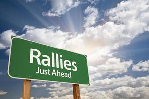 Rallies Green Road Sign Against Clouds photo
