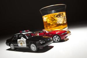 policía y coche deportivo junto a una bebida alcohólica foto