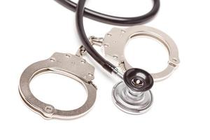 Stethoscope and Handcuffs on White photo