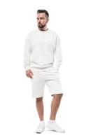 hombre vestido con sudadera blanca en blanco y pantalones cortos sobre fondo blanco foto