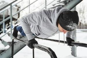 Athletic man doing push ups during his calisthenics winter workout photo
