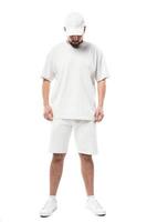 Man wearing blank white cap, t-shirt and shorts on white background photo