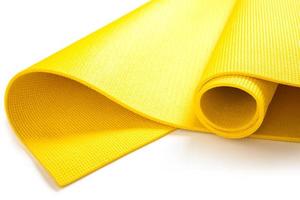 Closeup of yellow fitness mat on white background photo