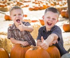 Two Boys Having Fun at the Pumpkin Patch on a Fall Day. photo