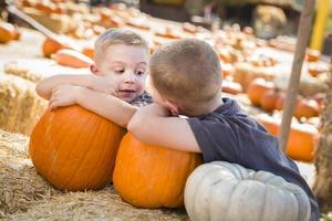Two Boys Having Fun at the Pumpkin Patch on a Fall Day. photo
