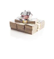 Small House on Stacks of Hundred Dollar Bills Isolated on a White Background photo