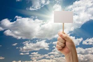 hombre con cartel en blanco sobre las nubes y el cielo foto