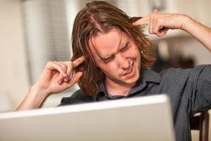 Young Man Getting Loopy While Using Laptop Computer photo