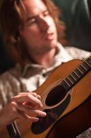 Young Musician Plays His Acoustic Guitar photo