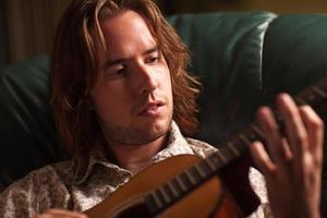 Young Musician Plays His Acoustic Guitar photo