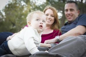 Cute Child Looks Up to Sky as Young Parents Smile photo