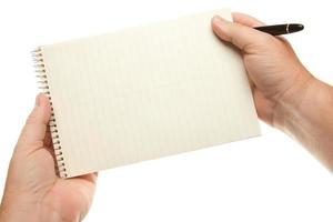 manos masculinas sosteniendo bolígrafo y bloc de papel foto