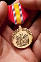 Man Holding National Defense War Medal photo