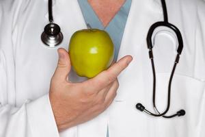 Male Doctor Holding Green Apple photo