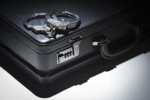 Pair of Handcuffs and Briefcase Under Spot Light photo