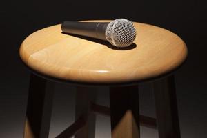 Microphone Laying on Wooden Stool Under Spotlight photo