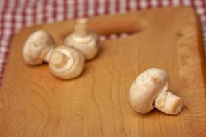 champiñones en tabla de cortar foto