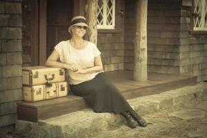 1920s Dressed Girl and Suitcases on Porch with Vintage Effect photo