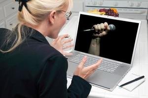 mujer emocionada en la cocina usando una laptop - libertad de expresión foto