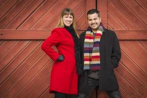 Mixed Race Couple Portrait in Winter Clothing Against Barn Door photo