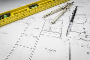 Construction Level, Pencil, Ruler and Compass Resting on House Plans photo