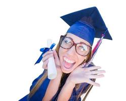 Goofy joven graduada en toga y birrete aislado sobre un fondo blanco. foto