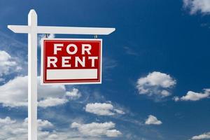 Right Facing For Rent Real Estate Sign Over Blue Sky and Clouds With Room For Your Text. photo