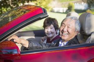 Happy Chinese Couple Enjoying An Afternoon Drive in Their Convertible photo