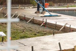 Construction Worker Smoothing Wet Cement With Trowel Tool photo