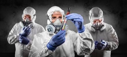 Team of Doctors or Nurses In Hazmat Gear Holding Positive Coronavirus Test Tube Banner photo