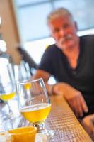 vaso de cerveza artesanal en el bar con un hombre guapo en segundo plano. foto