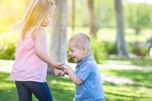 hermano y hermana jóvenes jugando juntos en el parque foto