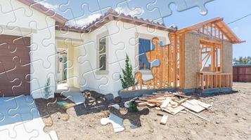 las piezas del rompecabezas encajan entre sí revelando la construcción de la casa terminada sobre el marco de la construcción foto