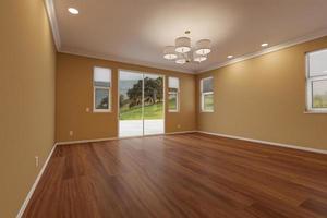 Newly Remodeled Room of House with Finished Wood Floors, Moulding, Dark Tan Paint and Ceiling Lights. photo