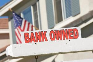 signo de bienes raíces propiedad del banco y casa con bandera americana foto