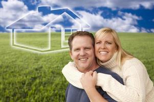 Happy Couple Hugging in Grass Field with Ghosted House Behind photo