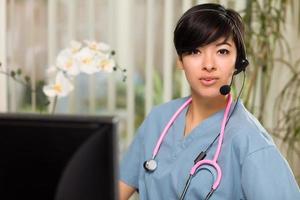 atractiva mujer multiétnica con auriculares, batas y estetoscopio foto